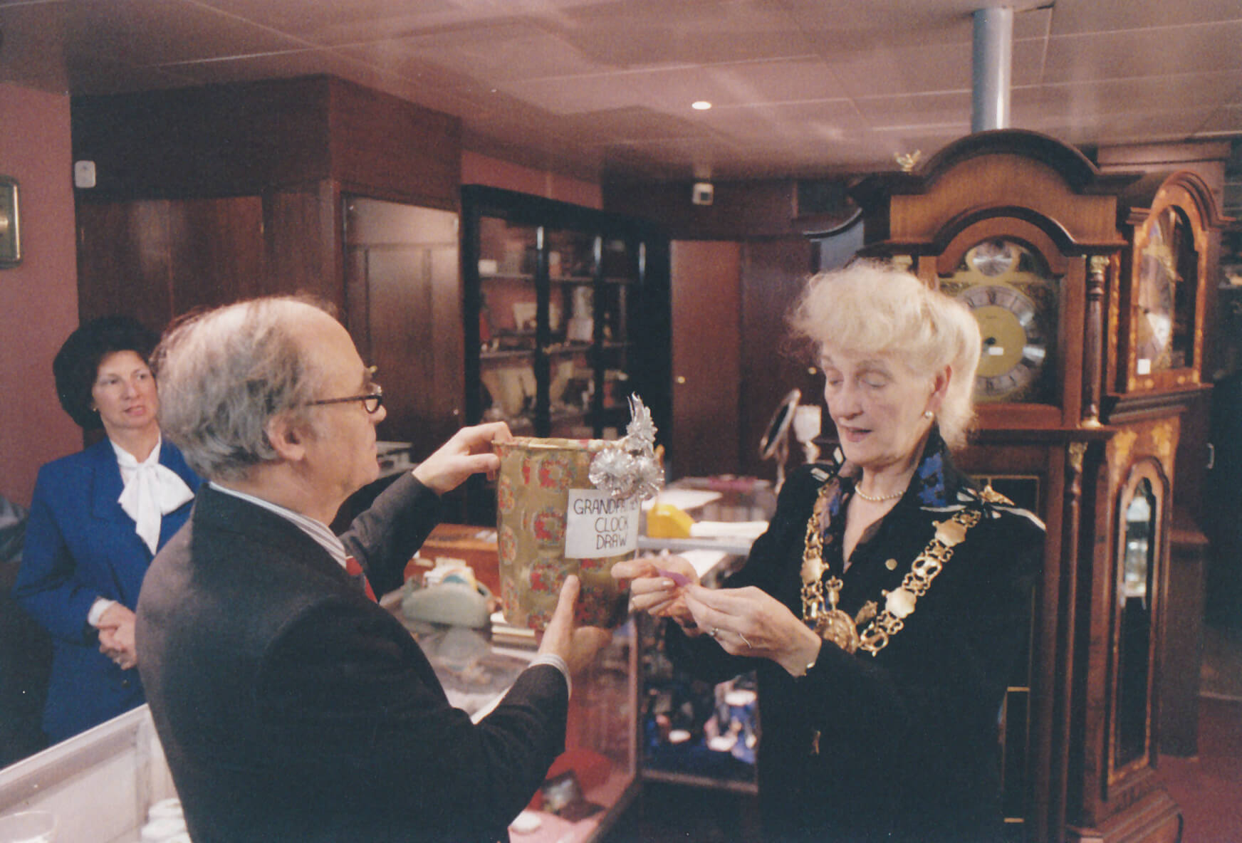 A mayor picks a raffle ticket from a box