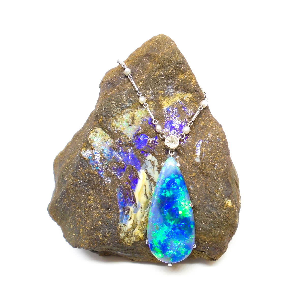 A blue opal necklace sits around a small rock.