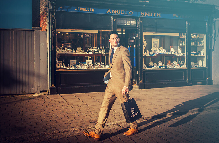 A customer walks past the shop holding an Angelo Smith bag